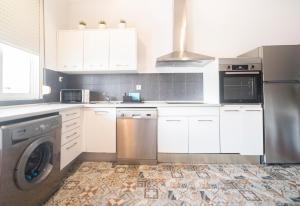 フェロルにあるApartamento Tierraの白いキャビネットと洗濯機付きのキッチン