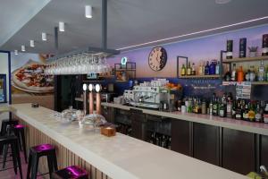 a bar in a restaurant with a clock on the wall at PENSION RESTAURANTE ANGEL in Huelma