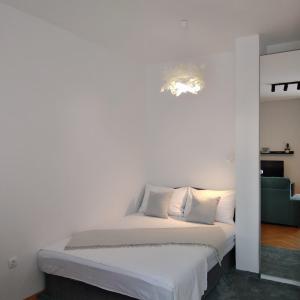 斯普利特的住宿－Sweet，白色卧室配有床和绿色沙发