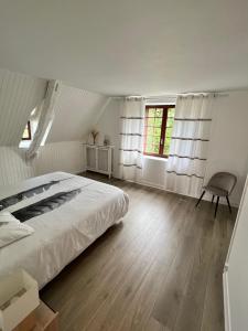 a bedroom with a bed and a chair in it at Superbe gîte à la campagne avec grand jardin et spa privé in Vernet-le-Bas