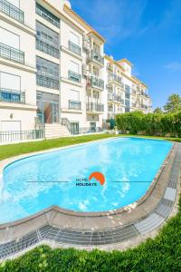 a large swimming pool in front of a building at #020 Olhos d'Água with Shared Pool, Heated Floor in Albufeira