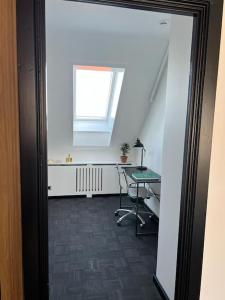 een kamer met een bureau, een tafel en een raam bij Designer apartment in Charlottenlund
