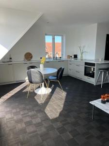 uma cozinha com mesa e cadeiras num quarto em Designer apartment em Charlottenlund