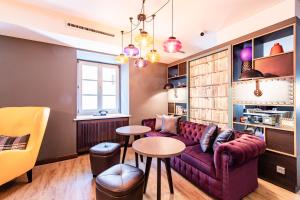 a living room with a purple couch and a table at Premier Inn Passau Weisser Hase in Passau