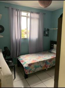a small bedroom with a bed and a window at Betim paraíso in Betim