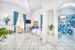 a blue and white bedroom with a bed and a bathroom at Le Botteghe 59 Capri in Capri