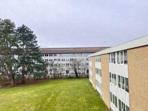 a large building with a grass field in front of it at Three Bedroom Apartment In Rdovre, Trnvej 45b, in Rødovre