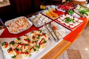 einen Tisch mit Vorspeisen und Teller mit Speisen in der Unterkunft Hotel Alfred in Karlsbad