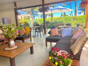 a living room with couches and tables and flowers at Hotel Cerrano in Silvi Marina