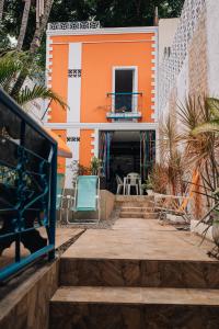 una casa naranja y blanca con escaleras y sillas en Pousada Bom Sucesso 59 en Olinda