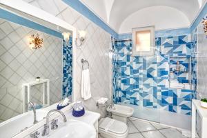 baño azul y blanco con bañera y aseo en Le Botteghe 59 Capri en Capri