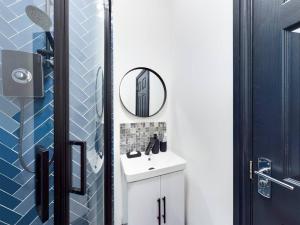 Luxurious 3 bedroom Flat في ليفربول: حمام مع حوض أبيض ومرآة