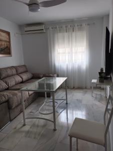 a living room with a glass table and a couch at APARTAMENTOS MATUTE in Almodóvar del Río