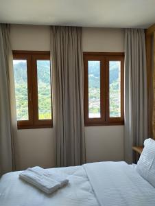 a bedroom with two towels on a bed with windows at Primula in Metsovo