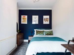 Luxurious 3 bedroom Flat في ليفربول: غرفة نوم بحائط ذات لهجة زرقاء وسرير