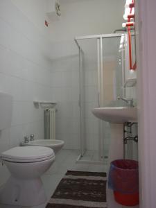 y baño con aseo y lavamanos. en Hotel Derna, en Viareggio