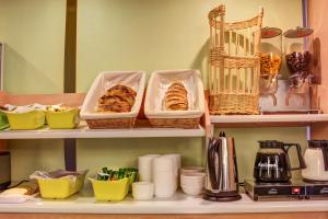 a shelf with baskets and other items on it at Hotel Inn Design Issoudun in Issoudun