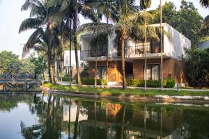 a building next to a river with palm trees at Dream Square Resort in Gazipur