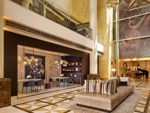a lobby with a couch and tables in a building at Hyatt Regency Al Kout Mall in Kuwait