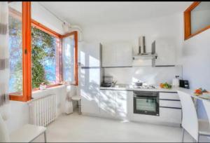 a white kitchen with a stove and a window at Apartment With View Lake Maggiore/Laveno Mombello in Laveno