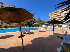 basen z parasolami i krzesłami obok basenu w obiekcie Apartamento Agata 510 Excelente con vista al mar!!! w mieście Benalmádena