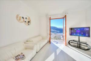 sala de estar con sofá blanco y TV de pantalla plana en Apartment With View Lake Maggiore/Laveno Mombello, en Laveno