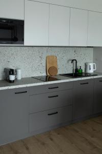 a kitchen with white cabinets and a sink at Apartament Radosny in Kudowa-Zdrój