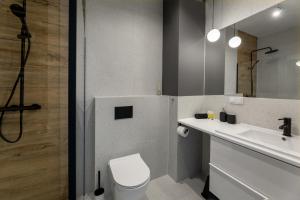 a bathroom with a toilet and a sink and a mirror at Apartament Radosny in Kudowa-Zdrój +9 photos