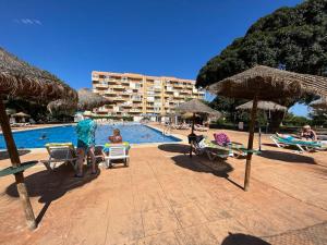 basen z krzesłami i parasolami w obiekcie Apartamento Agata 510 Excelente con vista al mar!!! w mieście Benalmádena