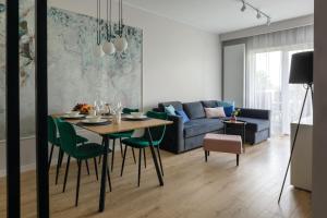 ein Wohnzimmer mit einem Tisch und einem Sofa in der Unterkunft Apartament Radosny in Kudowa-Zdrój