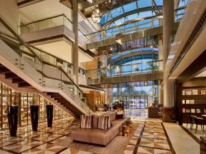 a lobby with a staircase and a couch in a building at Hyatt Regency Al Kout Mall in Kuwait