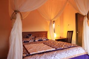 a bedroom with a canopy bed with white curtains at Gangga Homestay in Munduk