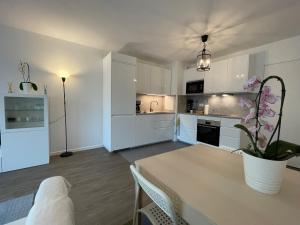 a kitchen with white cabinets and a table with a plant at Lovely apartment near to Paris in Créteil