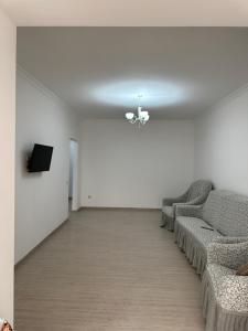 una sala de espera con sofás y TV en la pared en Апартаменты Esnat en Gudautʼa