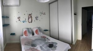 a bedroom with a bed with flowers and butterflies on the wall at Appartement cosy - vue mer in Le Robert