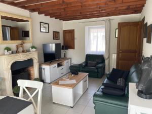 a living room with a couch and a fireplace at Le Courtil in Cerisy-la-Forêt