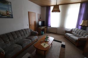 ein Wohnzimmer mit 2 Sofas und einem Couchtisch in der Unterkunft Hotel Weißes Roß in Altenbrak