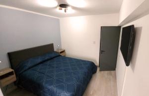 1 dormitorio con 1 cama azul y TV en Nice Full Apartment Downtown Salta en Salta