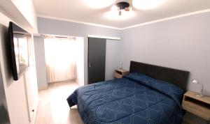 a bedroom with a blue bed and a window at Nice Full Apartment Downtown Salta in Salta