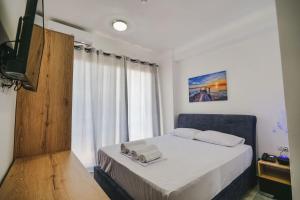 ein kleines Schlafzimmer mit einem Bett und einem Fenster in der Unterkunft Vullkan Hotel in Ksamil