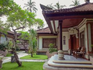 a house with a garden and a patio at Puri Bagus Candidasa in Candidasa