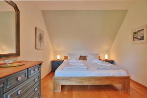- une chambre avec un lit et une commode en bois dans l'établissement Am Rosenhain 19 Am Rosenhain 19 Appartement 3, à Timmendorfer Strand