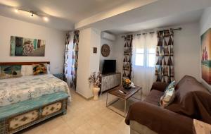 a bedroom with a bed and a couch at Estudios Costavigía Mazagón by Ramona in Mazagón