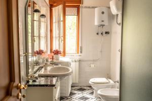 uma casa de banho com 2 lavatórios, um WC e uma janela em Casa Adele - Cilento em Ceraso