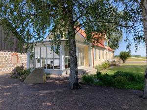 ein Haus mit einem Baum davor in der Unterkunft Slimmingegården in Skurup