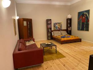 uma sala de estar com um sofá e uma cama em FeWo Grüne Mommsenstraße - bei Becker klingeln em Berlim