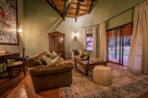 un soggiorno con un divano e un tavolo di Okapuka Safari Lodge a Windhoek