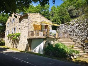 ReilhanetteにあるGîte La Magnanerieのバルコニーと階段付きの古い石造りの家