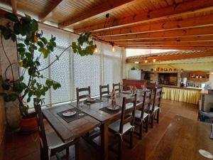 uma sala de jantar com uma longa mesa de madeira e cadeiras em Mirador de Caión. Casa Rural completa con Piscina em Cayón