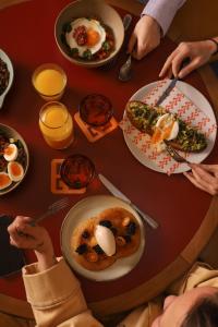 a group of people sitting around a table with food at The Hoxton, Brussels in Brussels